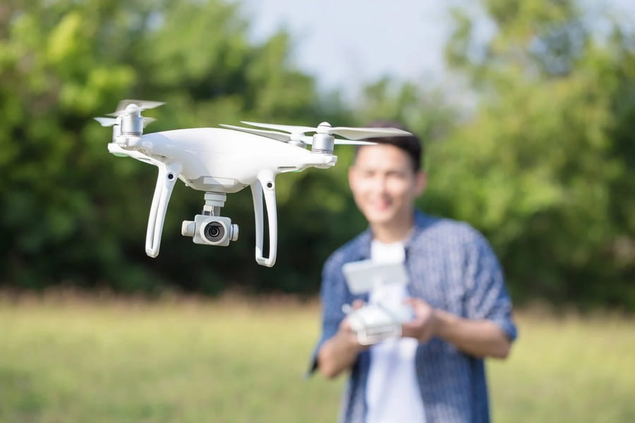 Operator flying an agricultural drone over Irish farmland by the coast