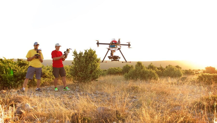 Researchers, engineers and farmers collaborating around a drone